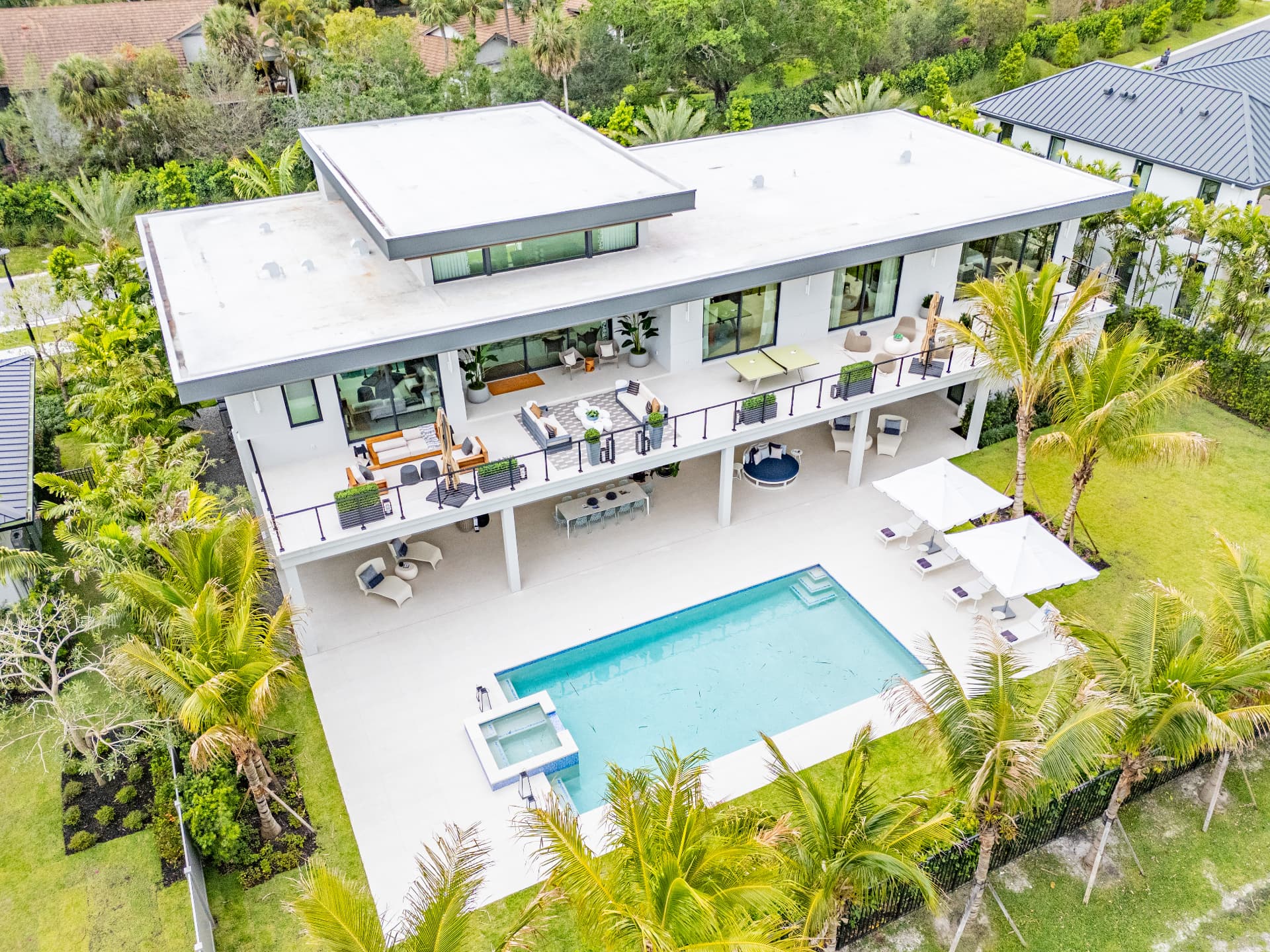 Flat-roof modern two-story custom home with covered terraces and pool at Farrell Estates in Wellington, Florida