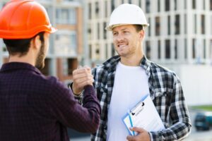 Construction workers shaking hands on site.