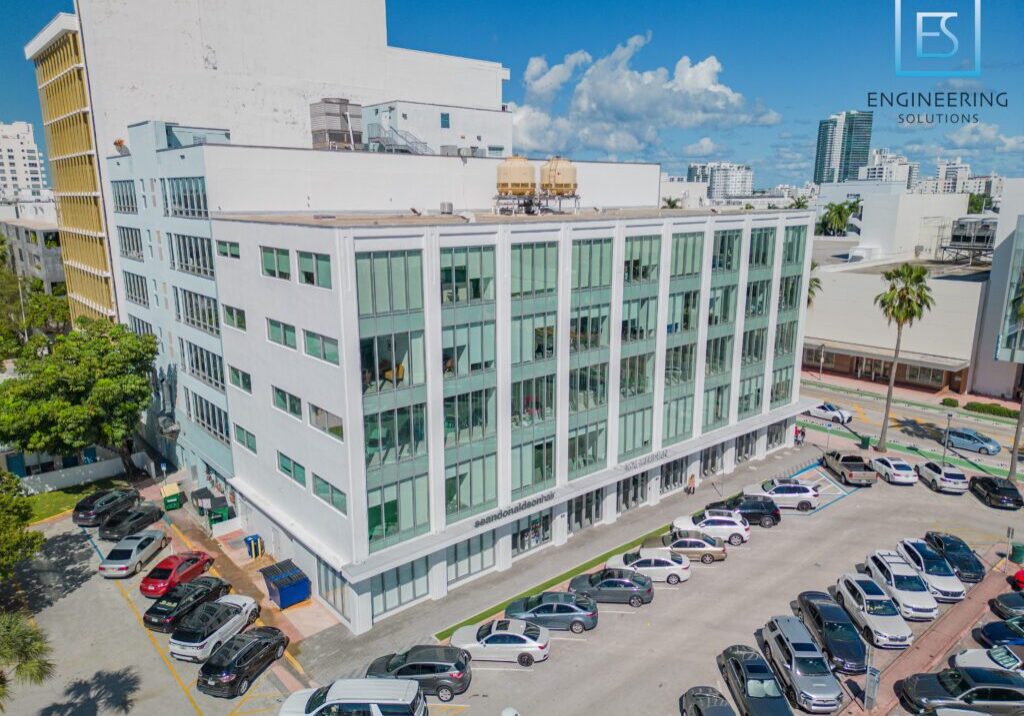 A building with many cars parked on the side of it.