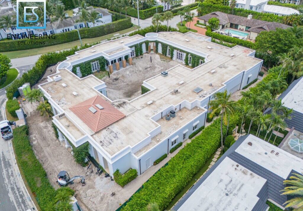 A large white building with many windows and lots of trees.